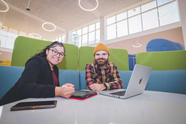 Students in Learning Commons looking at camera